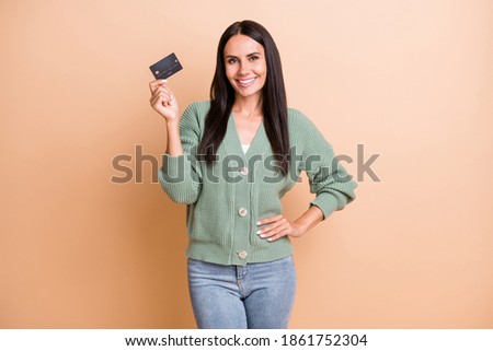 Photo of optimistic girl show card wear green sweater isolated on peach color background