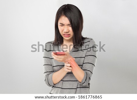 asian young woman holding mobile feel wrist bones pain 