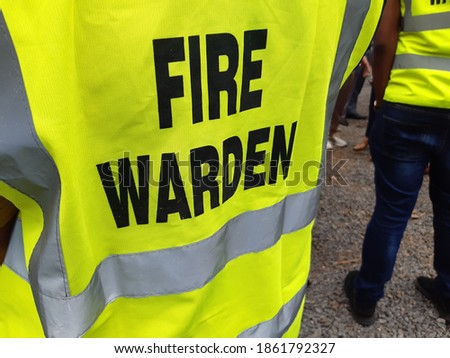 Yellow jacket showing fire warden on duty. Safety background. Royalty-Free Stock Photo #1861792327