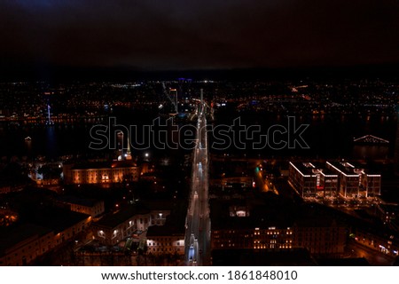 Panoramic view of city Riga center over old town at night. Long exposure night photography made with a drone. River Daugava and the bridge over it at night.