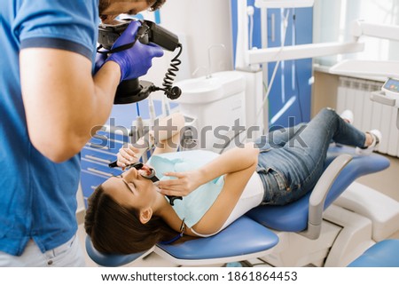 A man dentist take photo of patients teeth