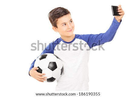 Boy holding football and taking a selfie isolated on white background