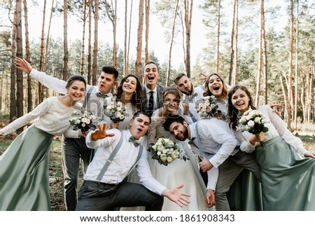 a beautiful couple of newlyweds in a circle of close friends laugh and have fun on the wedding day, a celebration of joy, a group of young people indulge