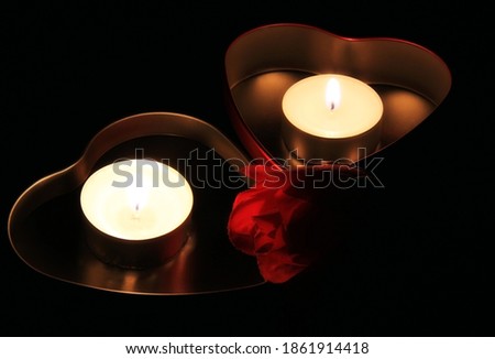 Pair of candles in the darkness, box heart shaped.