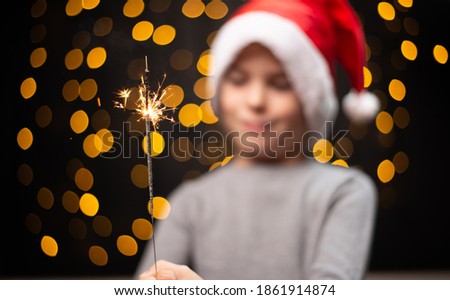 Cheerful young man holding sparkler in hand. Christmas New Year