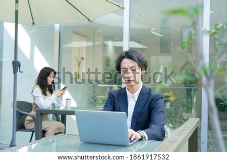 Asian woman working at the sidewalk cafe Royalty-Free Stock Photo #1861917532