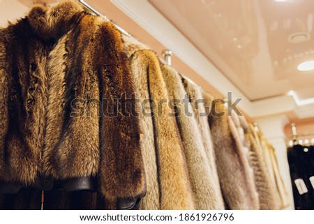 Mink coats of different colors in a shop on a hanger.