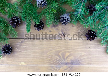 Christmas tree branches with red decorations on a wooden wall background. Template for greeting card or design.