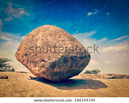 Vintage retro hipster style travel image of Krishna's butterball -  balancing giant natural rock stone with grunge texture overlaid. Mahabalipuram, Tamil Nadu, India Royalty-Free Stock Photo #186194744