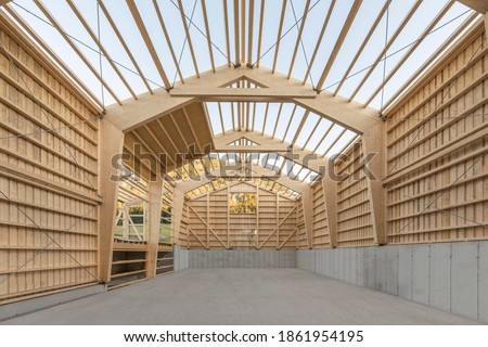 Large timber engineering hall under construction with laminated beams and concrete floor slab Royalty-Free Stock Photo #1861954195