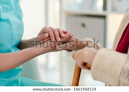Senior woman hand in caregiver hands
