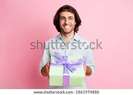 Photo of optimistic nice brown hair guy present gift wear spectacles shirt isolated on pastel pink color background