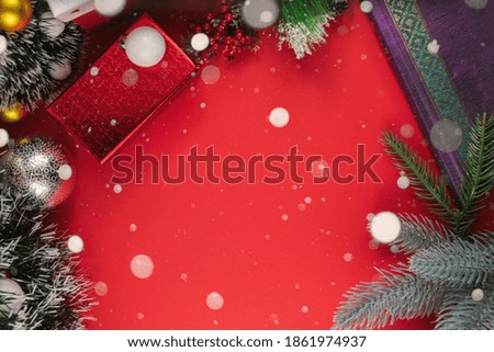 Christmas composition frame made of decorations on a red background, cozy photo with copy space and snow