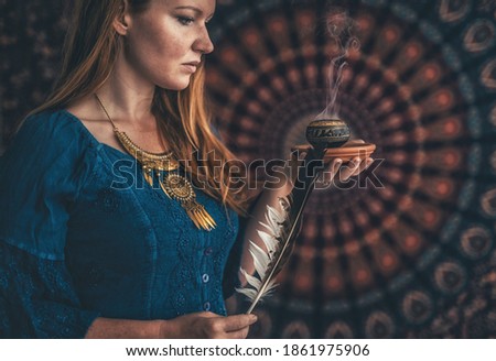 incense in a woman hand, incense smoke on a black background. Royalty-Free Stock Photo #1861975906