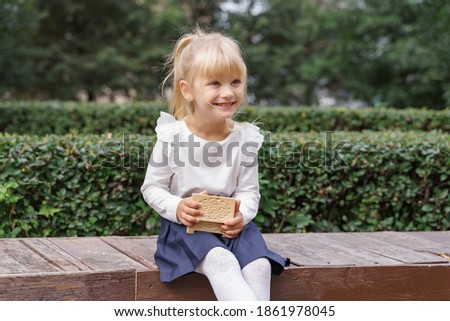cute blonde girl with wooden little casket outdoor