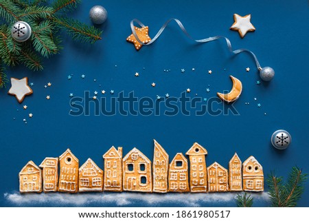 Christmas Cookies Village. Christmas landscape flat lay with Gingerbread cookies houses on dark blue background, top view, copy space.