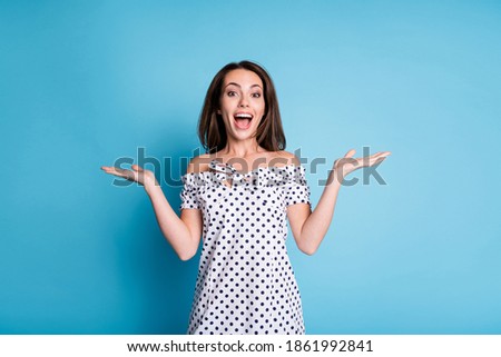 Photo of young girl excited open hands mouth look camera wear dotted dress isolated blue color background