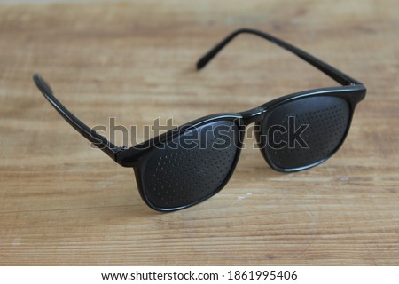 Black plastic raster glasses for eye and reading training and relaxation.