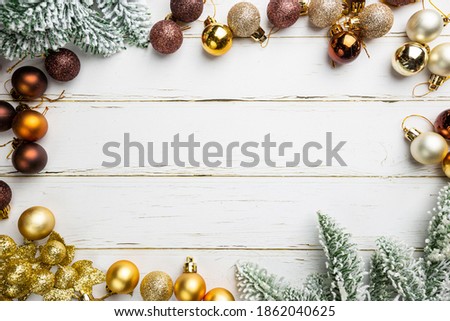 Christmas gold and brown decorations with fir tree branches on white wooden background, top view. Winter Decoration Background