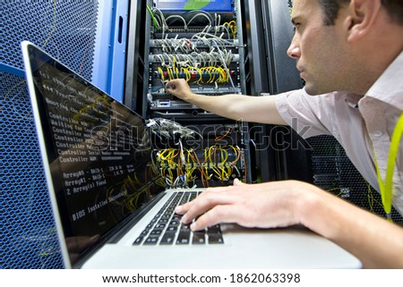 Technician with a laptop checking server in the data center