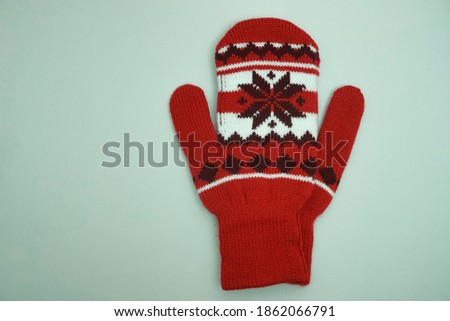 white, black and red  mittens isolated  on blue  background. empty copy space for inscription. snowflake pattern. 