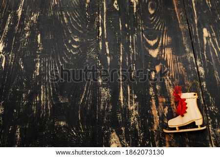 christmas flat lay with place for text, wooden skates lying on a dark wood table