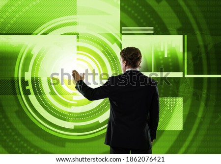 Businessman standing with back and using media virtual screen