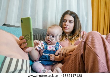 mom and baby watch cartoons from a smartphone