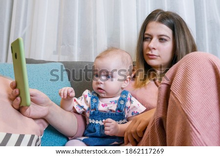 mom and baby watch cartoons from a smartphone