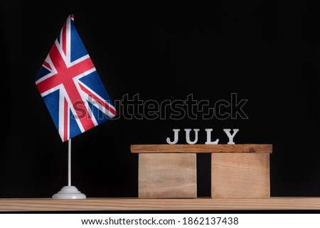 Wooden calendar of July with Great Britain flag on black background. Holidays of UK in July