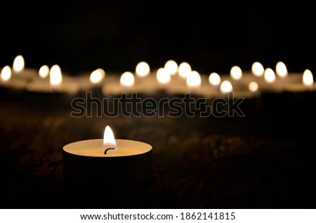 Many small christmas candles burning at dark. Shallow depth of field, selective focus
