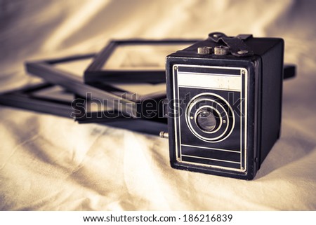 Vintage box camera and framed pictures with retro toning