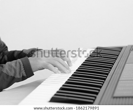 little boy hand playing the keyboard piano on white background stock photo