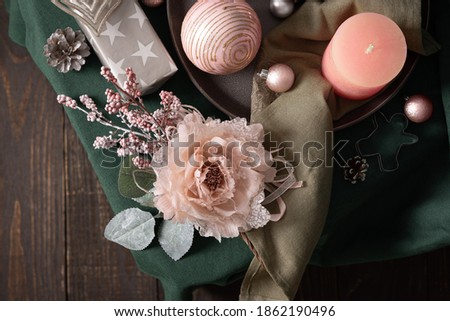 Christmas composition in sail champagne ,green and gray shades, christmas balls and candle, cookie cutters and decorative flower on a green tablecloth, top view, copy space