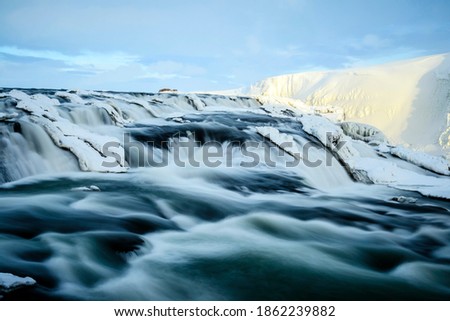 Time lapse view of river flowing over icy rock formations
