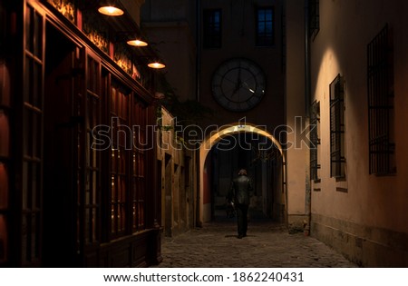 soft focus concept of Europe night backstreet town urban view arch alley dangerous place with unknown person in black coat back to camera criminal concept picture
