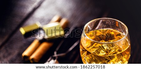 glass with whiskey and ice tongs in the background. Bar or pub image. Relaxation concept, luxurious lifestyle
