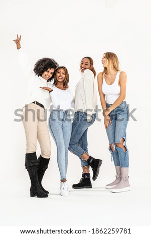 Group of young multi-ethnic attractive girls smiling and having fun together, posing in studio on white background. Friendship and real emotions concept.