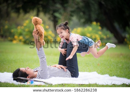 Asian kid are having fun with their mothers in the form of a vacation in the park.Mother's love concept, selective focus