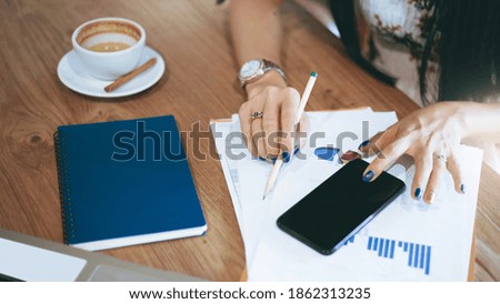 Top view. asian businesswoman work from home with paperwork of investment, computer laptop and smart phone on wooden table In situations with corona virus