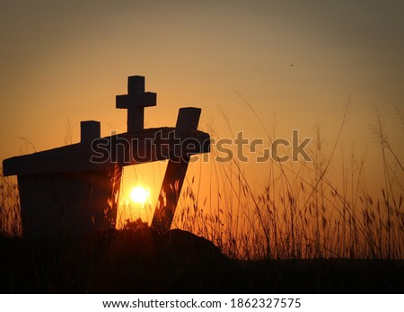 Beautiful sunset and a monument with a cross
