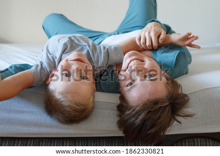  A happy woman and a boy in blue cloth embrace. Isolated on a white background. copy space. Game with son