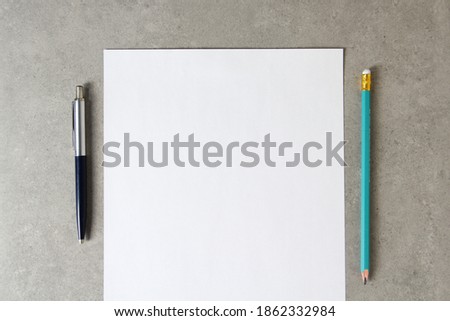 Template of white paper with a ballpoint pen and simple pencil on light grey concrete background. Concept of new idea, business plan and strategy, development and implementation of content. Stock