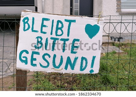 Sign on a fence in Germany with the inscription "please stay healthy" 