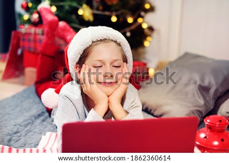 Boy having fun with wear holidays decor using online communitation by laptop. Distance Christmas party. Social distancing