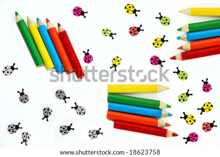 various small crayons and ladybirds isolated over white