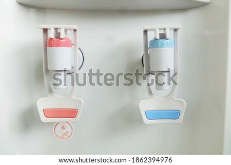 closeup of hot and cold faucet of water dispenser