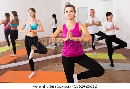 Women exercising yoga poses in fitness center. High quality photo