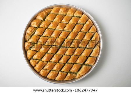 Baklava dessert in a tray sliced in a triangle from traditional Turkish cuisine Royalty-Free Stock Photo #1862477947