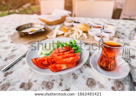 Traditional Turkish glass with strong tea, vegetables and other snacks for a rich middle eastern Breakfast in the outdoor restaurant